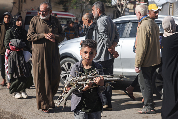 Un garçon ramasse du bois à Rafah, le 11 décembre 2023, alors que les combats se poursuivent entre Israël et le Hamas. (Photo MOHAMMED ABED/AFP via Getty Images)