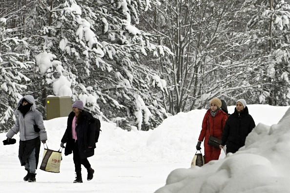 Des migrants arrivent au poste de contrôle frontalier de Vaalimaa entre la Finlande et la Russie à Virolahti, Finlande, le 15 décembre 2023. (Photo HEIKKI SAUKKOMAA/Lehtikuva/AFP via Getty Images)