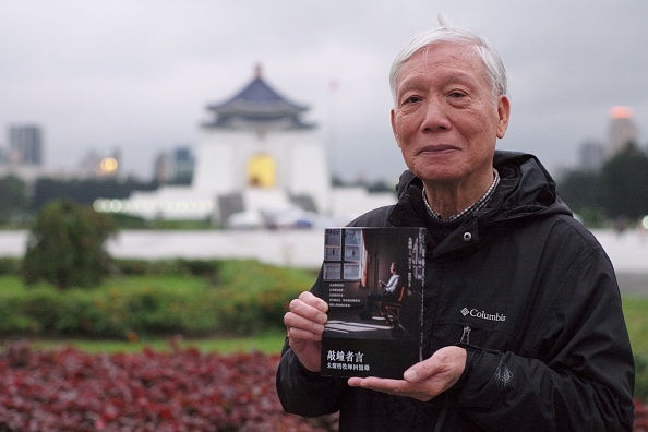 Le pasteur baptiste Chu Yiu-ming avec ses mémoires, « Confessions d'un sonneur de cloches », devant le Chiang Kai-shek Memorial Hall à Taipei. (Photo SAM YEH/AFP via Getty Images)