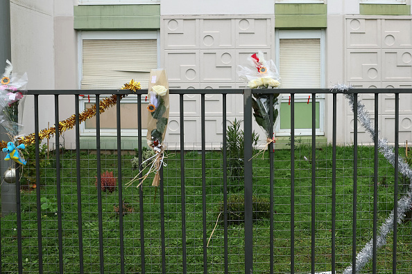 Cette photographie prise le 26 décembre 2023 montre des bouquets de fleurs sur la clôture juste devant l'appartement du rez-de-chaussée où les corps d'une femme et de ses quatre enfants ont été découverts, à Meaux, dans l'est de Paris.  (ALAIN JOCARD/AFP via Getty Images)