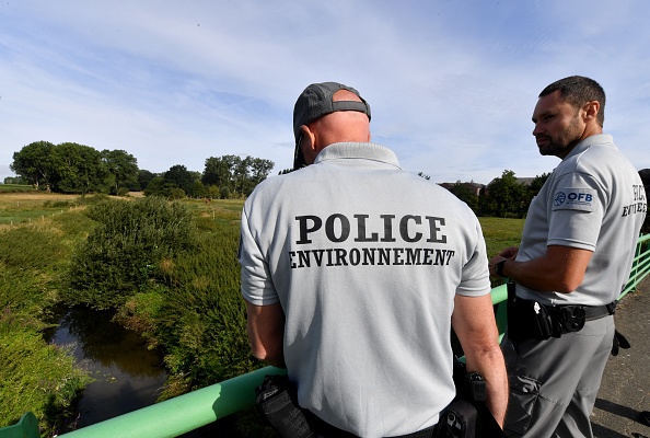 Des membres de l'Office français de la biodiversité (OFB) vérifient le niveau de l'Yser depuis un pont.  (Photo FRANCOIS LO PRESTI/AFP via Getty Images)