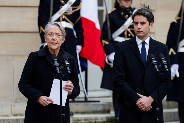 Le Premier ministre sortant Elisabeth Borne prononce un discours à côté du nouveau Premier ministre Gabriel Attal lors de la cérémonie de passation de pouvoirs à l'Hôtel Matignon à Paris, le 9 janvier 2024.   (LUDOVIC MARIN/POOL/AFP via Getty Images)