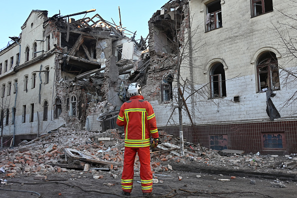 Un sauveteur ukrainien se tient à côté d'un immeuble résidentiel partiellement détruit par une attaque de missiles à Kharkiv, le 17 janvier 2024. (Photo SERGEY BOBOK/AFP via Getty Images)