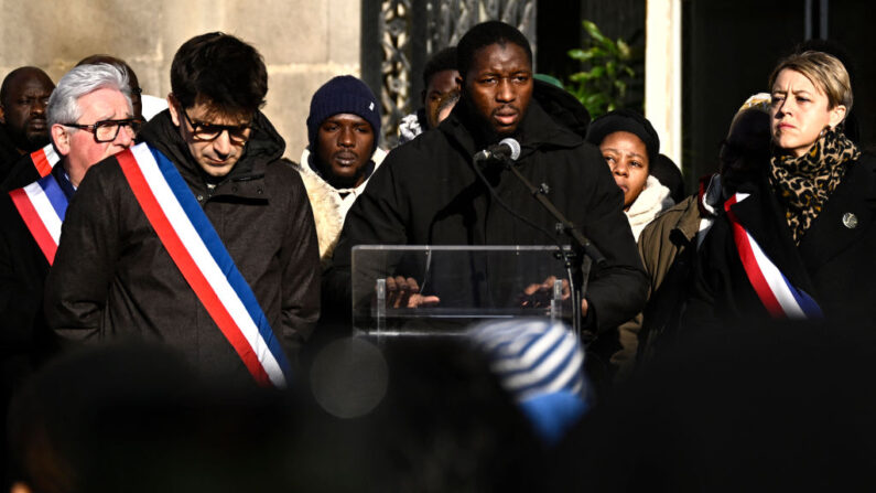 Le 20 janvier 2024, à Saint-Denis, le frère de Sedan, à côté du maire de la ville Mathieu Hanotin (à g.), prononce un discours lors d'un rassemblement en hommage à Sedan, un adolescent de 14 ans poignardé à mort sur un quai de la station de métro Basilique de Saint-Denis. (Photo JULIEN DE ROSA/AFP via Getty Images)