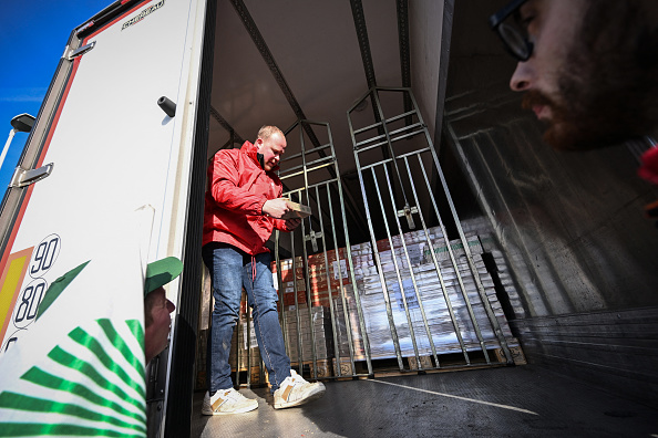 Des agriculteurs inspectent une cargaison de beurre dans des camions de transport alors qu'ils tiennent un barrage routier près de l'usine du géant laitier mondial Lactalis, à Isigny-le-Buat, dans le nord-ouest de la France, le 29 janvier 2024.  (LOU BENOIST/AFP via Getty Images)