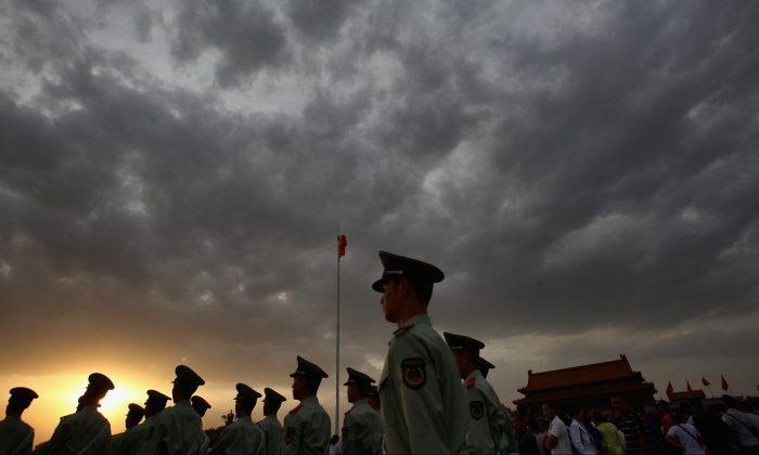 Des policiers paramilitaires patrouillent sur la place Tiananmen devant la Cité interdite à Pékin, le 18 mai 2011. (Feng Li/Getty Images)