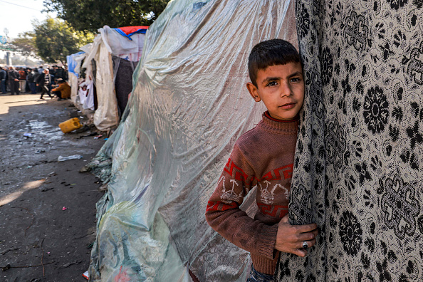 Un enfant sort d'une tente abritant des Palestiniens déplacés à Rafah, dans le sud de la bande de Gaza le 8 février 2024. (Photo MOHAMMED ABED/AFP via Getty Images)