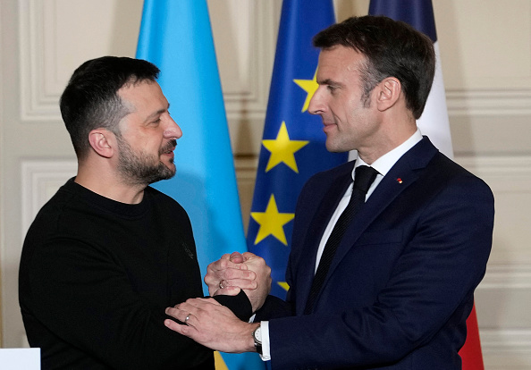 Le Président Emmanuel Macron serre la main du Président ukrainien Volodymyr Zelensky après la signature d'un accord de sécurité bilatéral. (Photo THIBAULT CAMUS/POOL/AFP via Getty Images)