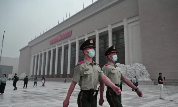 Des policiers chinois marchent devant le nouveau musée du Parti communiste chinois à Pékin, le 25 juin 2021. (Kevin Frayer/Getty Images)