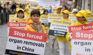 Des pratiquants du Falun Gong portent des affiches pour sensibiliser le public aux prélèvements forcés d'organes en Chine lors d'une marche dans le centre de Varsovie, en Pologne, le 9 septembre 2022. (Mihut Savu/Epoch Times)