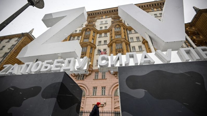 Un homme passe devant d'énormes lettres Z et V, insignes tactiques des troupes russes en Ukraine, placées devant l'ambassade des États-Unis dans le centre de Moscou, le 30 novembre 2023. (ALEXANDER NEMENOV/AFP via Getty Images)