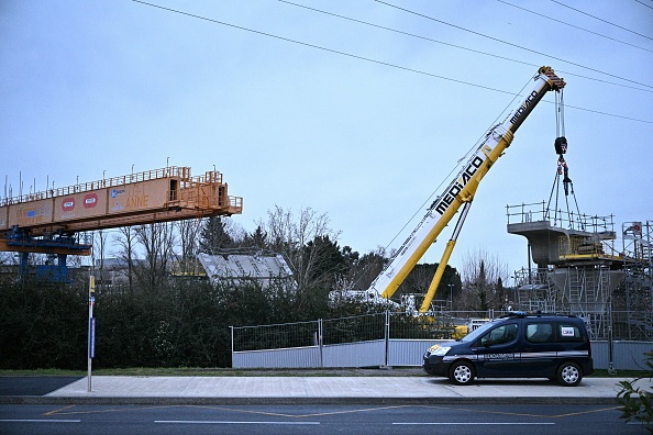 Une voiture de gendarmerie est garée devant le chantier où le tablier d'un pont s'est effondré, à Labège le 04 mars 2024. (Photo LIONEL BONAVENTURE/AFP via Getty Images)