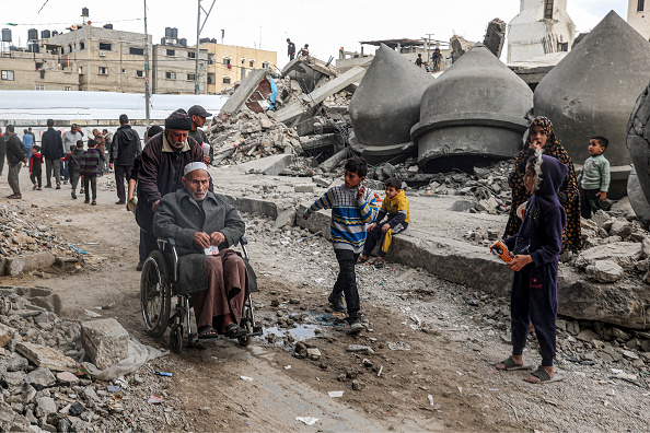 Des personnes passent devant les décombres de la mosquée Al-Faruq, détruite lors d'un bombardement israélien, à Rafah. (Photo SAID KHATIB/AFP via Getty Images)