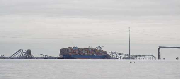 Une partie de la structure en acier du pont Francis Scott Key repose sur le porte-conteneurs Dali après l'effondrement du pont à Baltimore, Maryland, le 26 mars 2024. (Photo MANDEL NGAN/AFP via Getty Images)