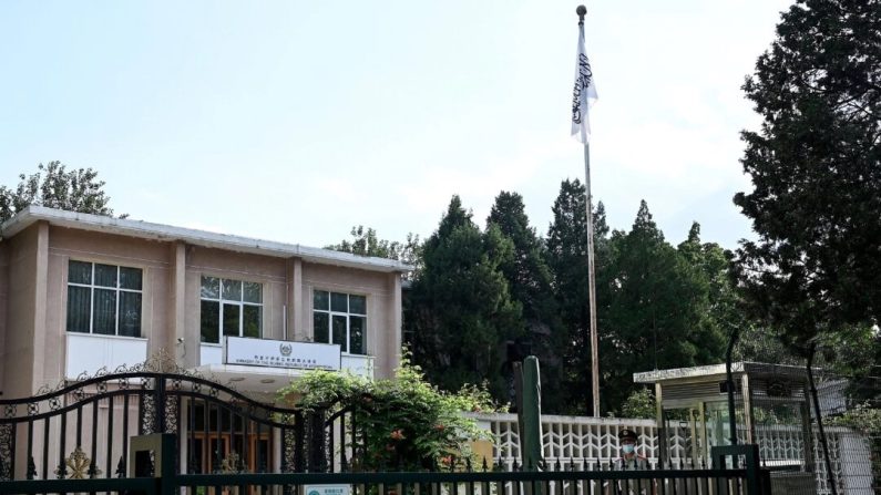 Un policier paramilitaire chinois monte la garde devant l'ambassade d'Afghanistan, avec un drapeau taliban affiché dans l'enceinte, à Pékin le 16 août 2022. (Noel Celis/AFP via Getty Images)