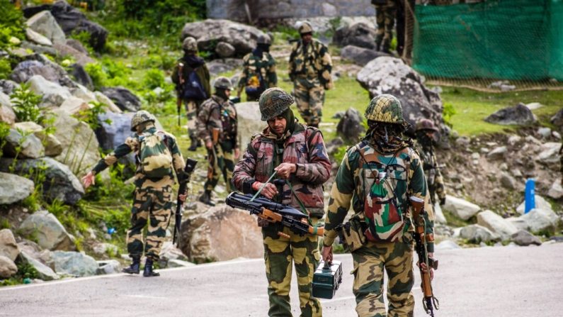 Des soldats des forces de sécurité frontalières indiennes patrouillent au passage d'un convoi de l'armée indienne sur une autoroute menant à Leh, à la frontière chinoise, à Gagangir, en Inde, le 19 juin 2020. (Yawar Nazir/Getty Images)