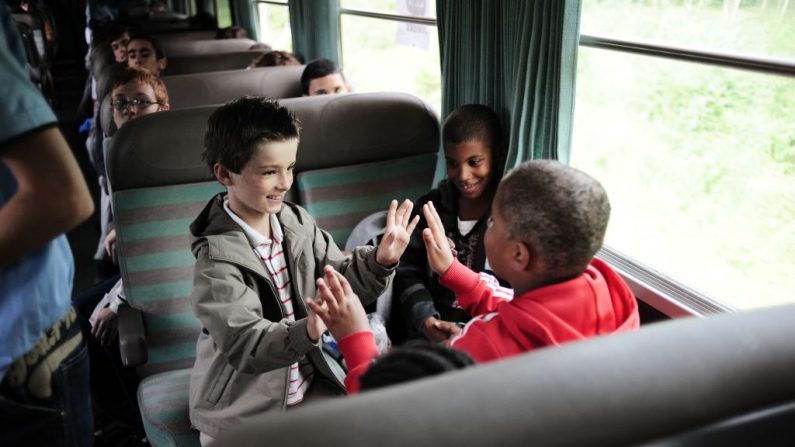 Des enfants jouent dans un train lors d'un voyage en colonie de vacances en Isère, le 13 juillet 2008 à Dijon. (Photo FRED DUFOUR/AFP via Getty Images)