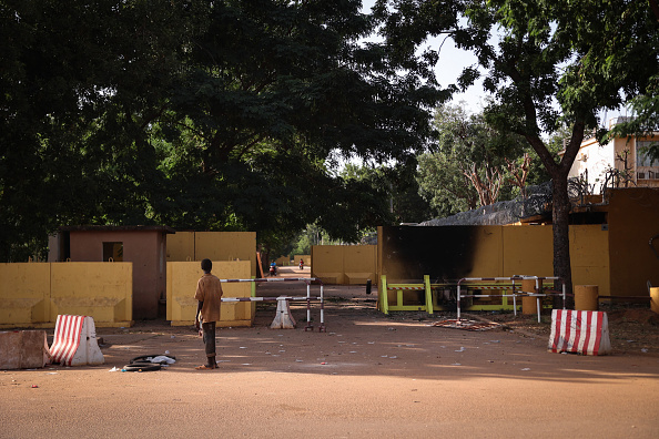 Un homme s'arrête devant l'entrée endommagée de l'ambassade de France à Ouagadougou, le 3 octobre 2022. (Photo OLYMPIA DE MAISMONT/AFP via Getty Images)