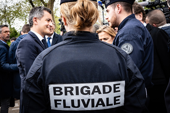 Gerald Darmanin s'entretient avec des membres de la Brigade fluviale de la police française lors d'une visite consacrée aux mesures de sécurité avant la cérémonie d'ouverture des Jeux olympiques à Paris, le 9 avril 2024. (MATHILDE KACZKOWSKI/Hans Lucas/AFP via Getty Images)