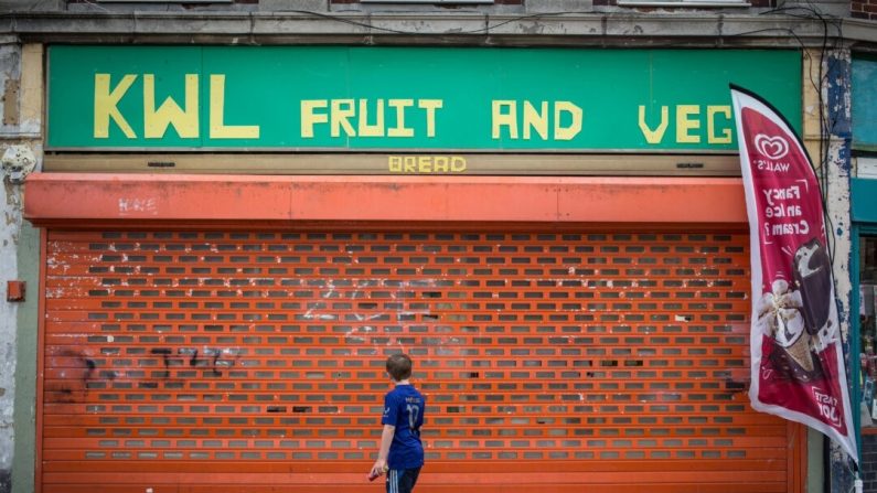 Un garçon passe devant un magasin fermé dans un quartier résidentiel de Bristol, en Angleterre, le 3 août 2015. (Matt Cardy/Getty Images)