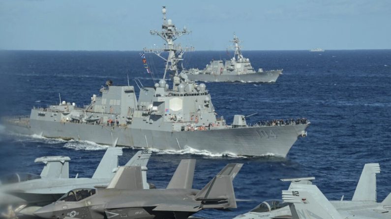 Un navire militaire chinois (à l'arrière, à droite) observe les destroyers à missiles guidés de classe Arleigh-Burke USS Sterett (à l'avant) et USS Rafael Peralta (à l'arrière) depuis le pont du porte-avions USS Carl Vinson lors d'un exercice maritime de trois jours entre les États-Unis et le Japon dans la mer des Philippines, le 31 janvier 2024. (Richard A. Brooks/AFP via Getty Images)