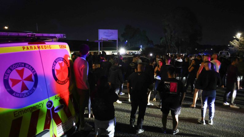 Des habitants se rassemblent avec la police pour surveiller le périmètre de l'église Christ the Good Shepherd dans la banlieue ouest de Sydney, à Wakeley le 15 avril 2024, après que plusieurs personnes ont été poignardées dans les locaux de l'église. (Photo DAVID GRAY/AFP via Getty Images)