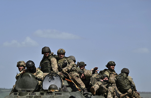 Des militaires ukrainiens sur un véhicule blindé de transport de troupes (APC) dans un champ près de Chasiv Yar, le 27 avril 2024. (Photo GENYA SAVILOV/AFP via Getty Images)