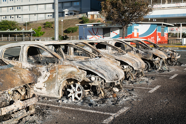 Une photo montre des voitures brûlées sur le parking de l'ancien hôpital à la périphérie de Nouméa, le 16 mai 2024. (Photo DELPHINE MAYEUR/AFP via Getty Images)