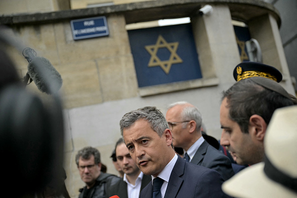 "Ce jeune policier a sauvé des vies » a déclaré le ministre de l'Intérieur Gerald Darmanin (au c.), devant la synagogue de la ville de Rouen où a eu lieu le drame, le 17 mai 2024. (Photo LOU BENOIST/AFP via Getty Images)