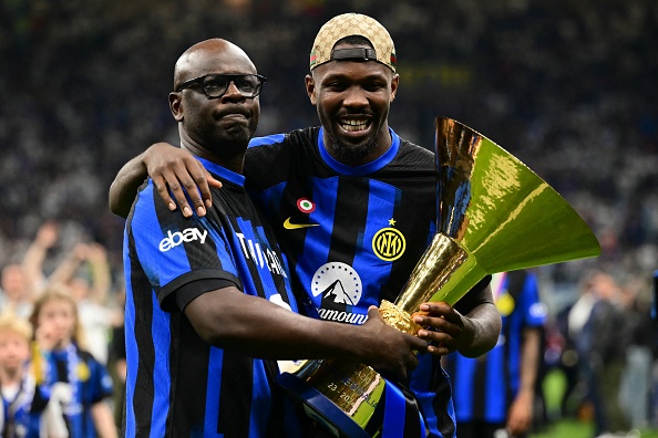 L'ancien joueur international français Lilian Thuram et son fils, Marcus, après le match de football de la Serie A italienne entre l'Inter Milan et la Lazio à Milan, le 19 mai 2024. (MARCO BERTORELLO/AFP via Getty Images)