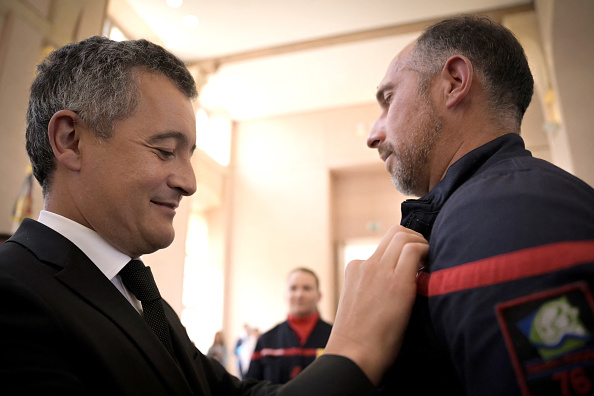 Le ministre de l'Intérieur, Gérald Darmanin récompense un pompier lors d'une cérémonie de remise de décorations aux policiers et pompiers qui sont intervenus alors qu'un homme tentait d'incendier une synagogue, à Rouen, le 20 mai 2024. (Photo LOU BENOIST/AFP via Getty Images)