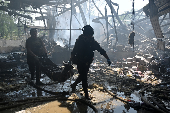 Les forces de l'ordre portent le corps d'une personne tuée lors d'une attaque au missile à Kharkiv le 23 mai 2024. (Photo SERGEY BOBOK/AFP via Getty Images)