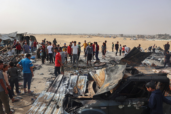 Des Palestiniens se rassemblent sur le site d'une frappe israélienne sur un camp de personnes déplacées à Rafah le 27 mai 2024. (Photo EYAD BABA/AFP via Getty Images).