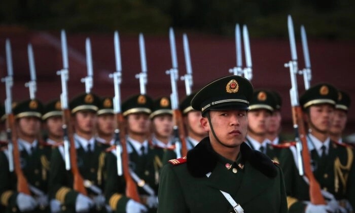 Un officier de police paramilitaire monte la garde lors de la cérémonie de descente du drapeau sur la place Tiananmen, à Pékin, en Chine, le 13 novembre 2012. (Feng Li/Getty Images)