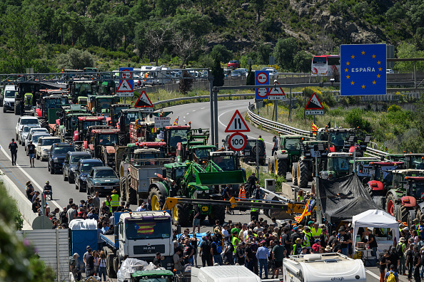 Des tracteurs d'agriculteurs espagnols et français arrivent pour bloquer une autoroute à la frontière entre l'Espagne et la France, près de Perpignan, le 3 juin 2024. (ED JONES/AFP via Getty Images)