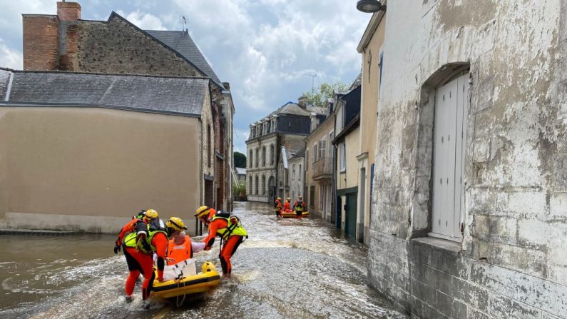 Des sauveteurs interviennent dans une rue inondée à Craon, le 20 juin 2024. (LAETITIA DREVET/AFP via Getty Images)