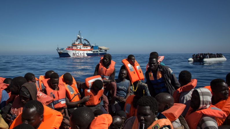 Des réfugiés et des migrants attendent d'être secourus d'un bateau surchargé par des membres de l'équipage du navire Phoenix du Migrant Offshore Aid Station (MOAS), le 18 mai 2017 au large de Lampedusa, en Italie. (Chris McGrath/Getty Images)