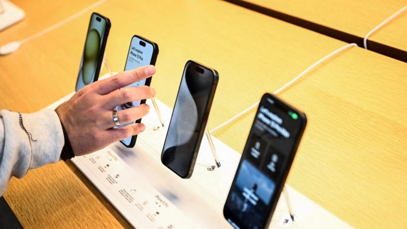 Un client compare les appareils de la série iPhone 15 d'Apple présentés à la vente dans le magasin Apple Grove le jour de la sortie à Los Angeles, Californie, le 22 septembre 2023. (Patrick T. Fallon/AFP via Getty Images)