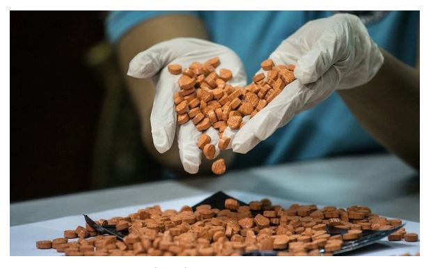 Un employé du Bureau des douanes (BOC) montre les drogues illégales confisquées, communément appelées ecstasy, lors d'une conférence de presse au siège du BOC à Manille, aux Philippines, le 14 septembre 2016. (Noel Celis/AFP/Getty Images)