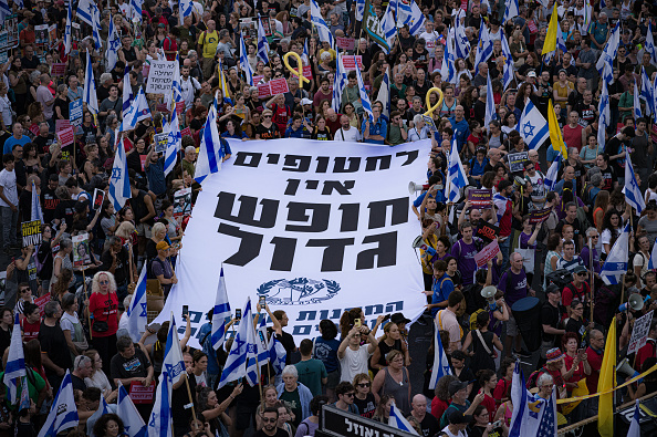 Des manifestants tiennent une pancarte "Pas de vacances d'été pour les otages" à Tel-Aviv, Israël, le 07 juillet 2024. (RAPHAEL GOTHEIL/Hans Lucas/AFP via Getty Images)