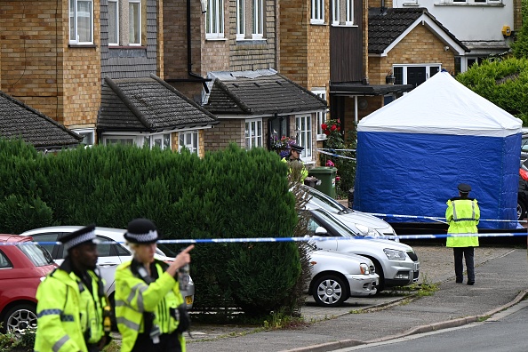 Des policiers montent la garde près d'une tente de l'équipe médico-légale à Ashley Close à Bushey dans l'arrondissement de Hertfordshire, au nord de Londres, le 10 juillet 2024, après un triple meurtre par "attaque à l'arbalète". (JUSTIN TALLIS/AFP via Getty Images)