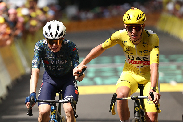 Le coureur slovène de l'équipe UAE Team Emirates, Tadej Pogacar (à dr.), tient la main du coureur danois Jonas Vingegaard, pour le féliciter après qu'il a franchi la ligne d'arrivée pour remporter la 11e étape de la 111e édition du Tour de France cycliste, le 10 juillet 2024. (ANNE-CHRISTINE POUJOULAT/AFP via Getty Images)