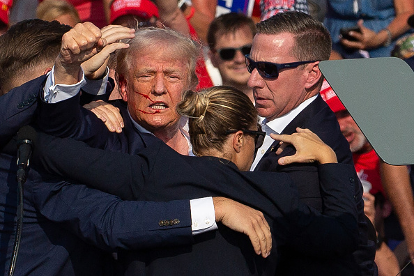 Donald Trump avec du sang sur le visage, entouré d'agents des services secrets, à Butler Farm Show Inc. à Butler, en Pennsylvanie, le 13 juillet 2024. (REBECCA DROKE/AFP via Getty Images)