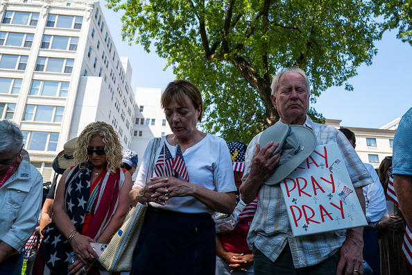 Des personnes prient lors d'une veillée de prière et d'un événement d'inscription des électeurs pour l'ancien président Donald Trump. (Spencer Platt/Getty Images)