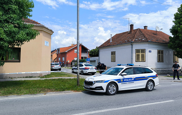 Des policiers croates montent la garde devant une maison de retraite (à g.) lors d'une fusillade à Daruvar, le 22 juillet 2024. (NIKOLA BLAZEKOVIC/AFP via Getty Images)