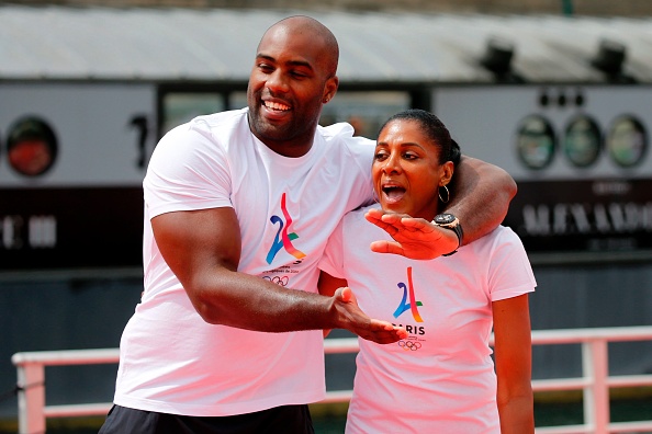 Marie-José Pérec, ici avec Teddy Riner, portera la flamme olympique à Paris avec notamment Thierry Henri, Jamel Debbouze, Gaël Fickou, Thomas Sotto ou encore Laura Flessel. (Photo JEAN-PAUL PELISSIER/AFP via Getty Images).