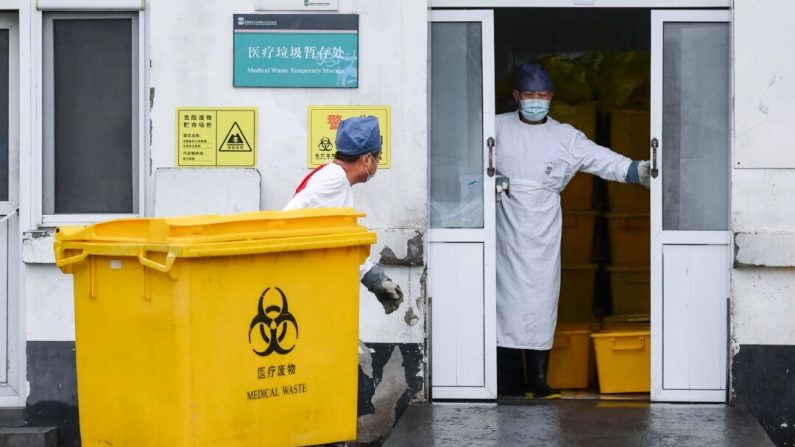 Un ouvrier transporte une poubelle chargée de déchets médicaux vers une installation de stockage dans un hôpital de Pékin, en Chine, le 14 février 2020. (Greg Baker/AFP via Getty Images)