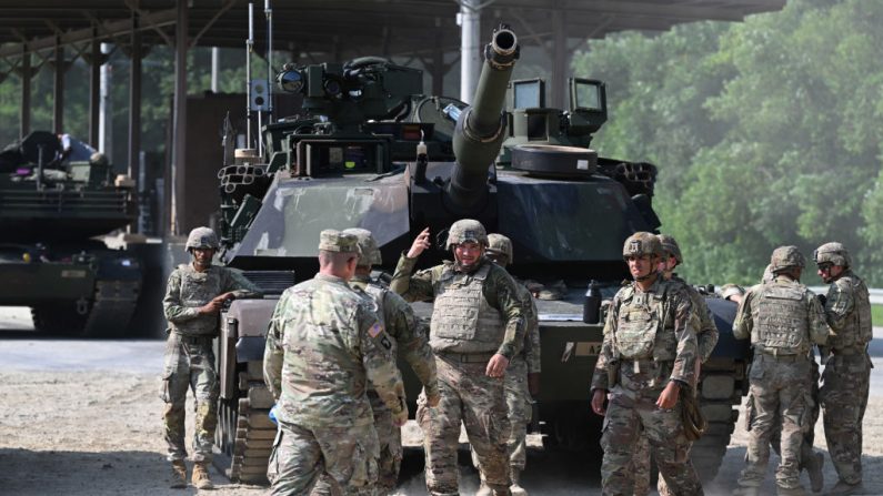 Des soldats américains de la 1st Armored Brigade Combat Team, 1st Armored Division se tiennent à côté d'un char américain M1A2 Abrams lors d'un exercice militaire à balles réelles au Rodriguez Live Fire Complex à Pocheon le 14 août 2024, afin de maîtriser leur compétence pour des réponses rapides depuis les États-Unis. (JUNG YEON-JE/AFP via Getty Images)