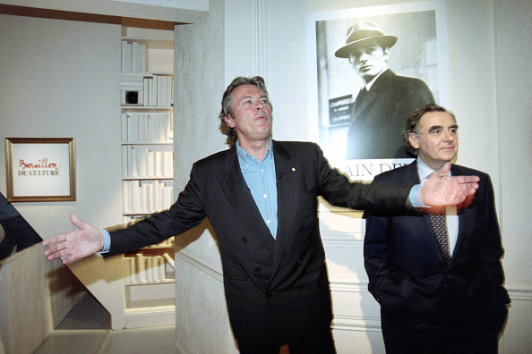 Alain Delon et Bernard Pivot devant une affiche du film "Le Samouraï" le 1er mars 1996.  (Photo PIERRE BOUSSEL/AFP via Getty Images)