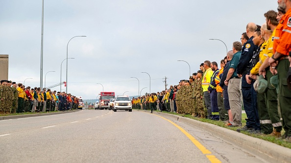 Procession en l'honneur d'un pompier décédé 
de l'Alberta Wildland Fire à Hinton, en Alberta. Le feu de forêt "hors de contrôle" a dévoré jusqu'à la moitié de la ville principale du parc national de Jasper, dans l'ouest du Canada. 400 pompiers étrangers ont été appelés en renfort. (Photo  CORPORAL PETER GRIEVES/Canadian Armed Forces/AFP via Getty Images)